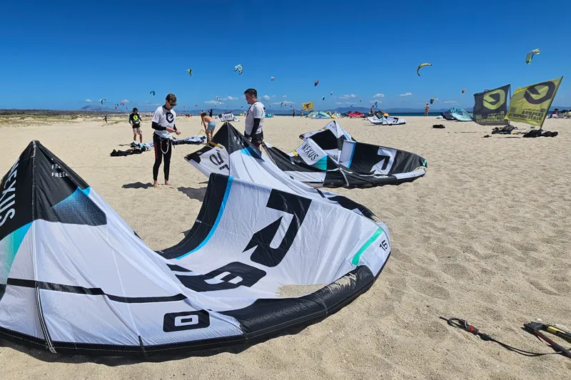 Kitesurf-Schüler bereiten Kites am sandigen Strand von Explora Watersports Tarifa vor