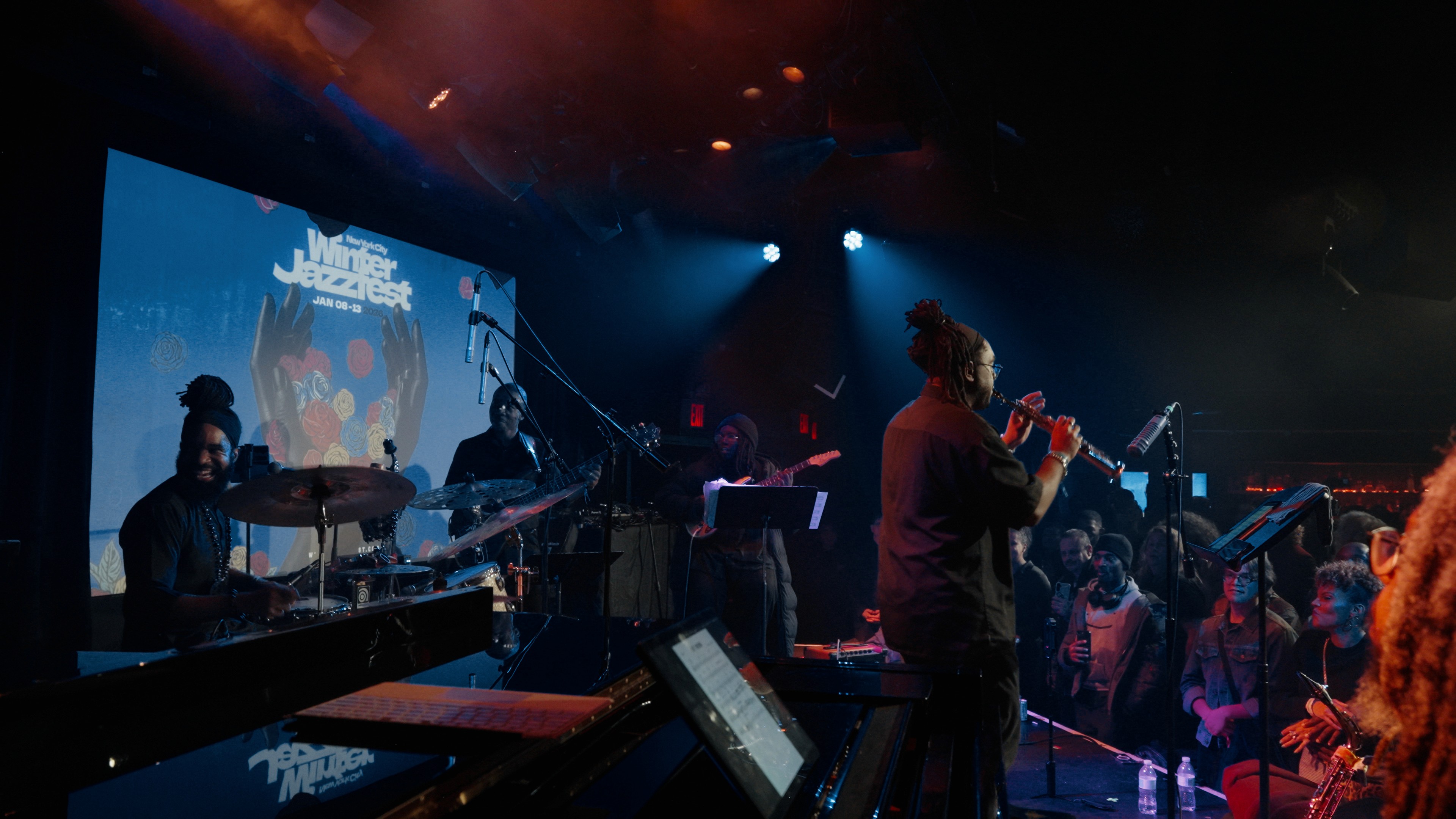  Collaborative work session overhead view of six people collaborating at a rustic wooden table with coffee, papers, and a laptop