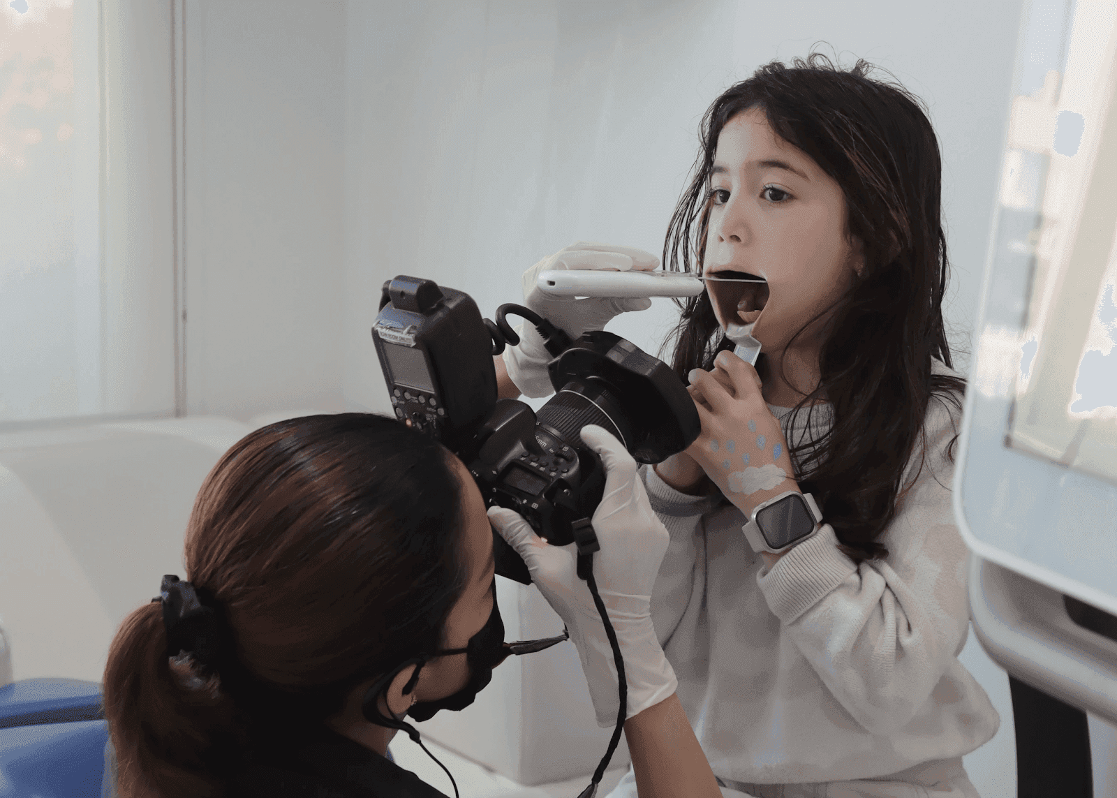 طبيبة أسنان أطفال بمركز انفزلاين الطبي بدبي تستخدم أحدث التقنيات للكشف عن تسوس الاسنان للاطفال لدى طفلة صغيرة من أجل اختيار العلاج الأمثل للتسوس.