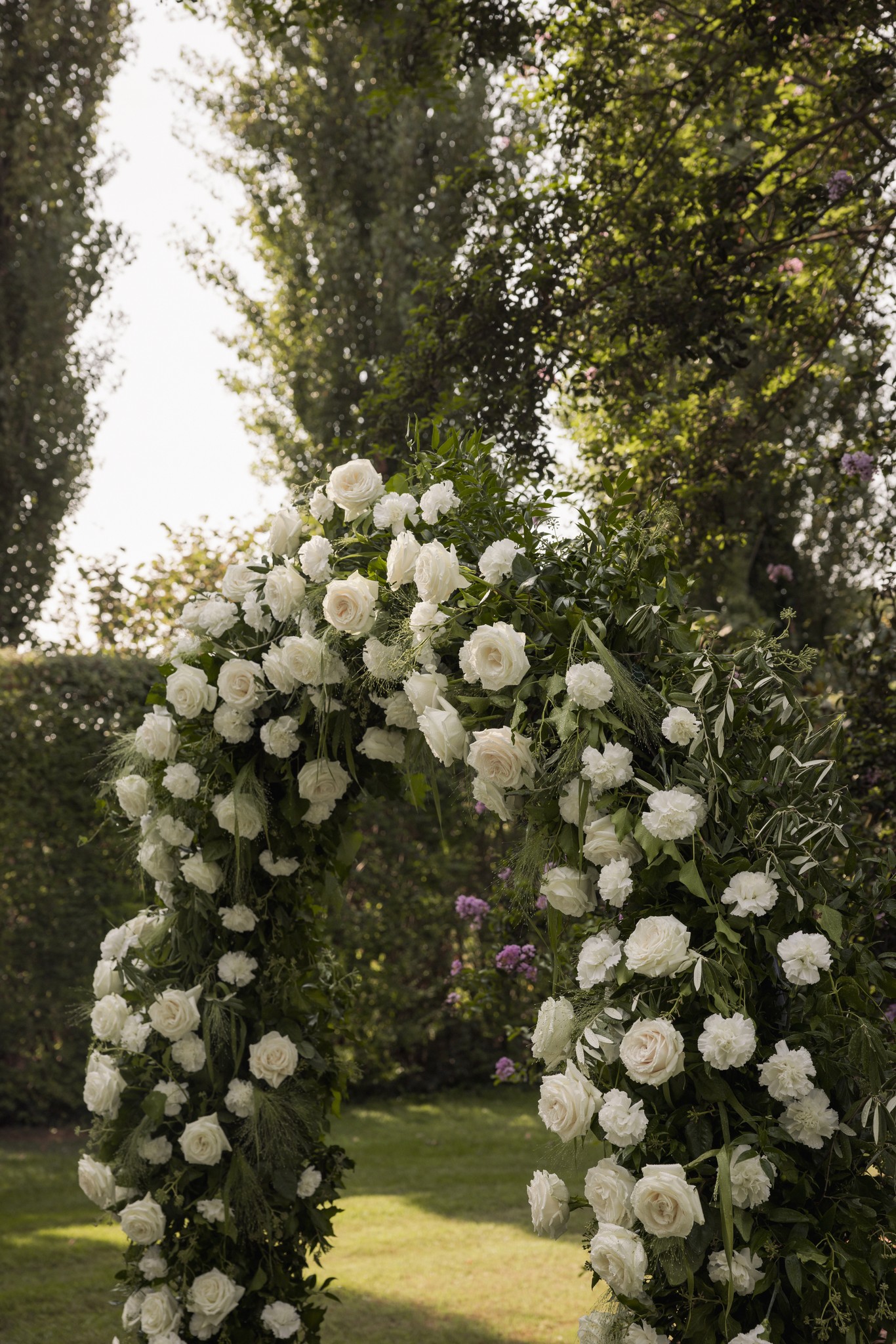 Arco floreale di rose bianche nel giardino di Villa Negri, cerimonia matrimoniale tra viali alberati