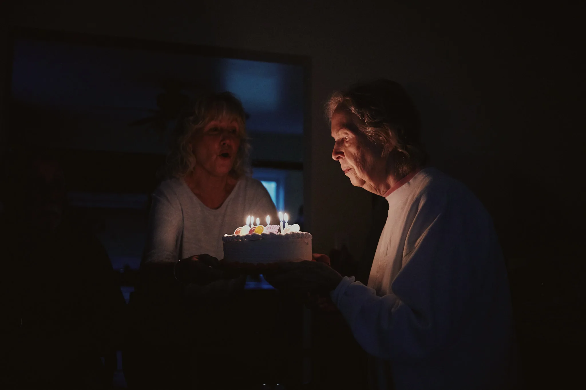two women lit by birthday candles — lifestyle photography by Tom Kubik