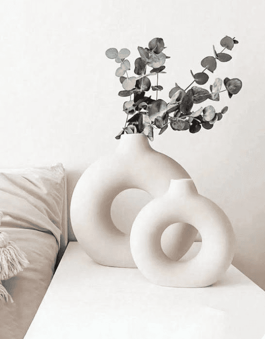 village near cliff and body of water under white clouds