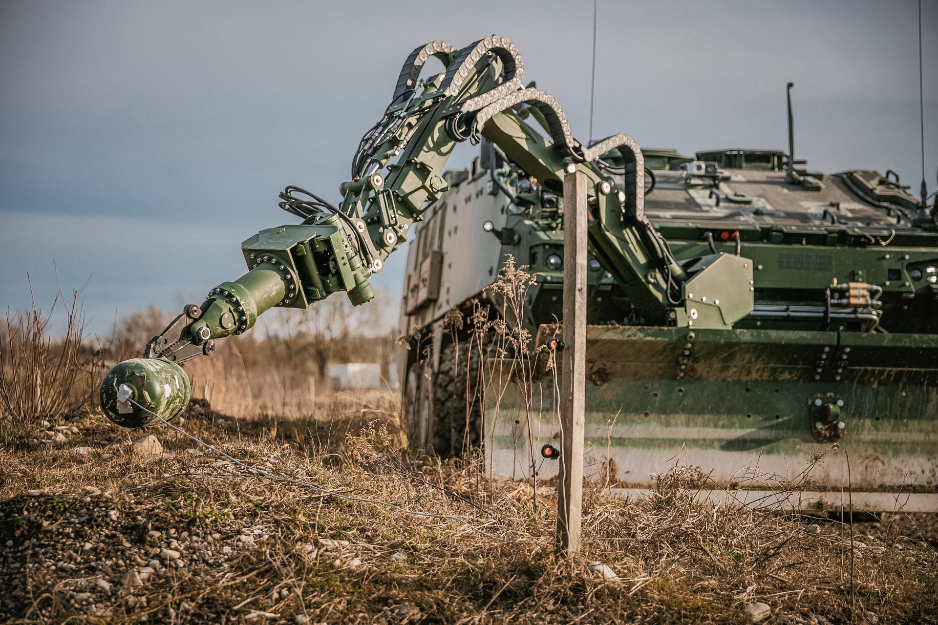 GCS manipulator arm attachment on a Piranha IV vehicle during route clearance, reaching towards an IED.