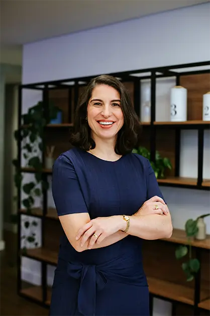 Empreendedora com postura profissional e feliz trabalhando no computador, representando o crescimento ao migrar de MEI para CNPJ.