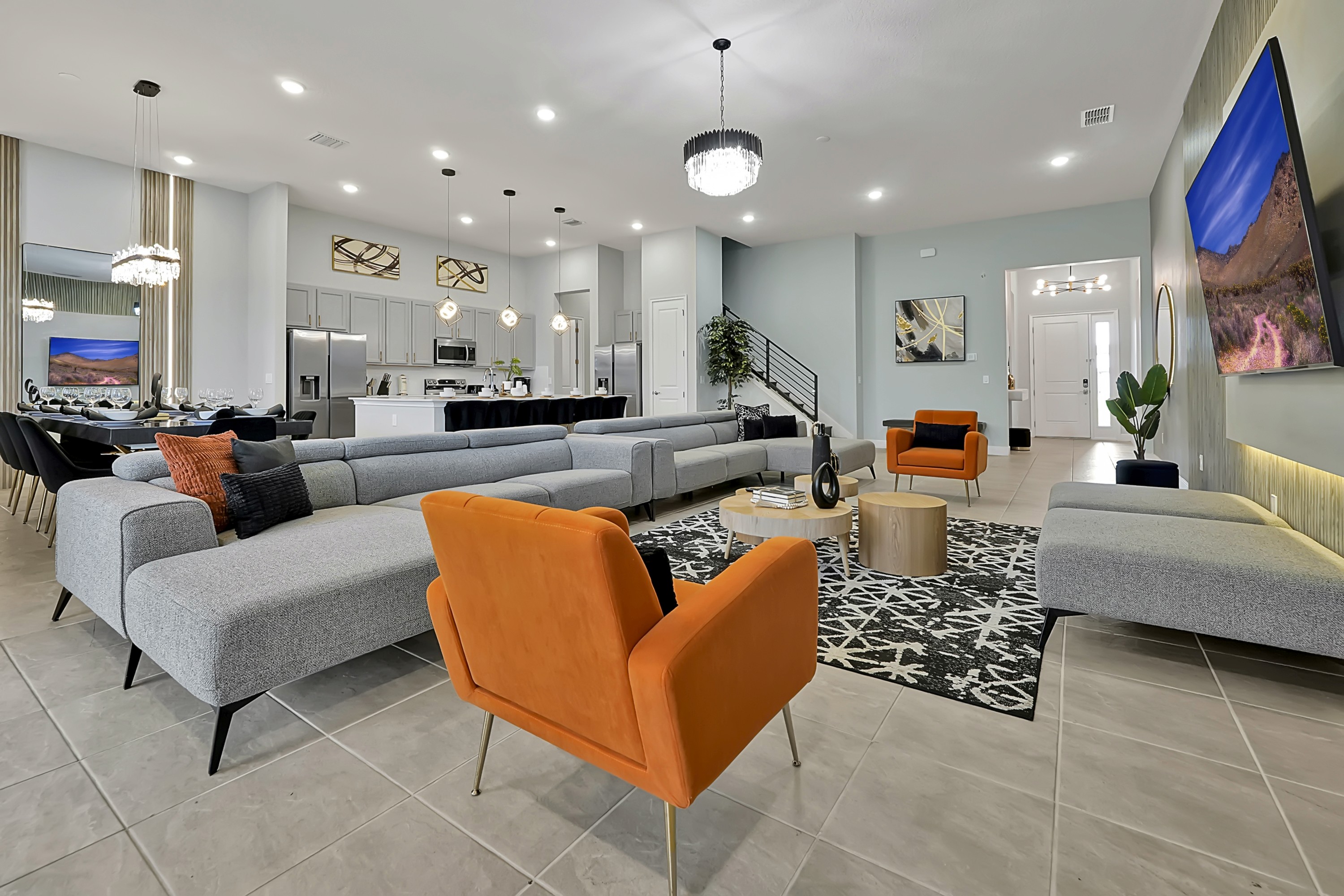 Open-plan vacation rental living room with sectional seating, dining area, and kitchen.