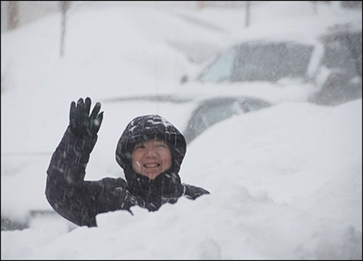A photo of a person standing in the snow an waving .