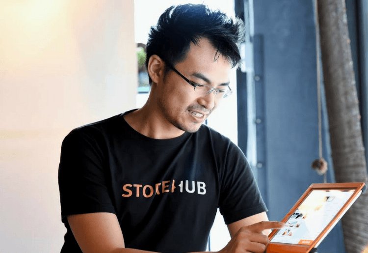 StoreHub CEO holding phone