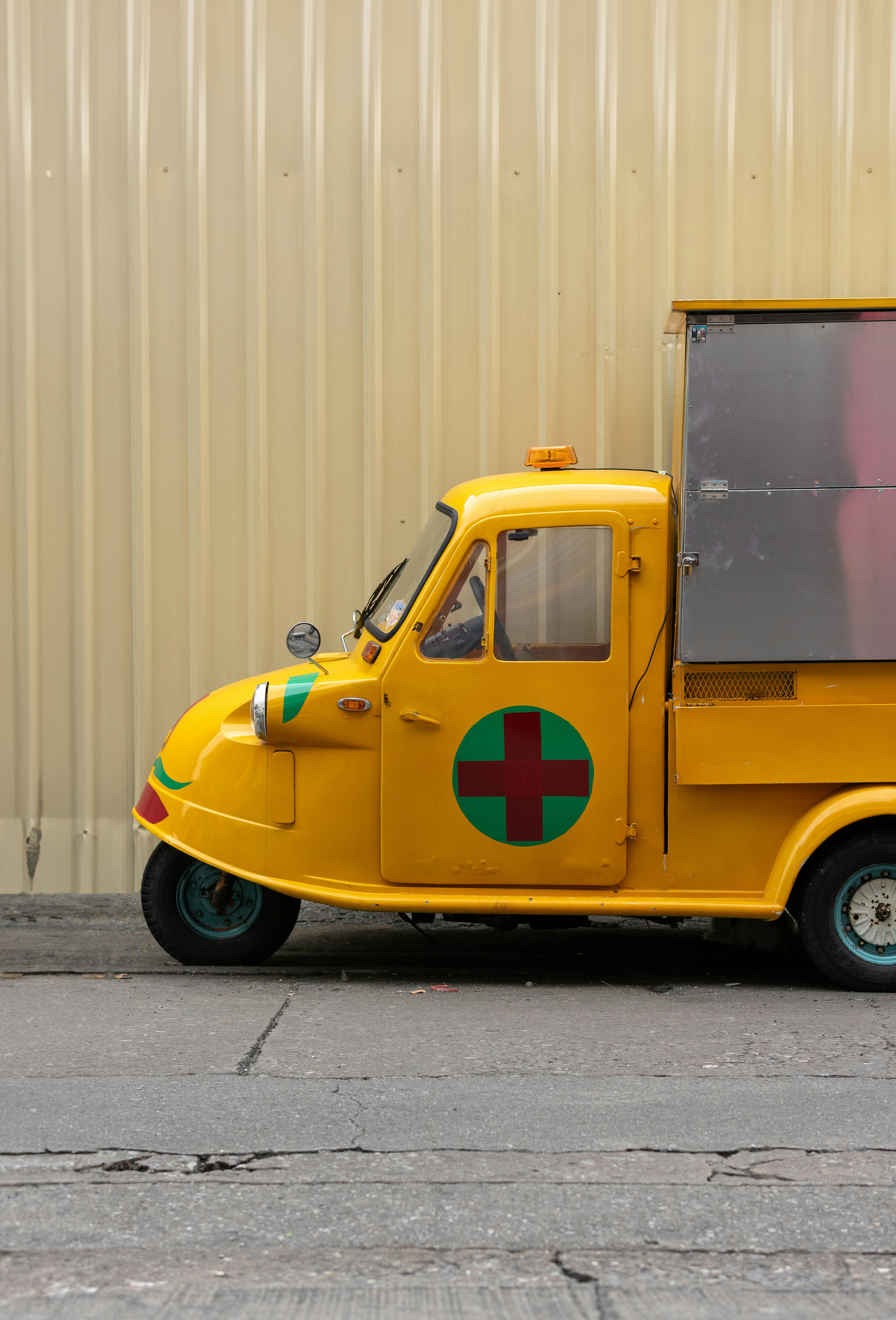 a yellow truck with a green cross painted on the side
