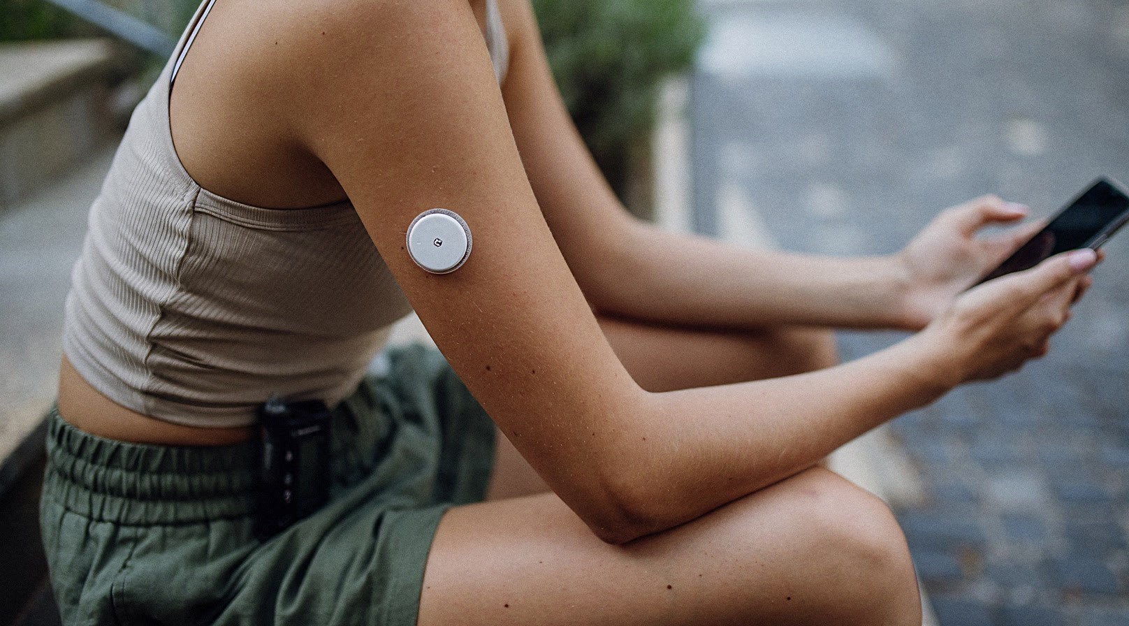 Woman wearing a continuous glucose monitor for metabolic health screening and personalized longevity testing.