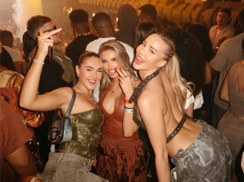 Belgrade nightlife girl friends having good time in nightclub, smiling to camera and cheering.