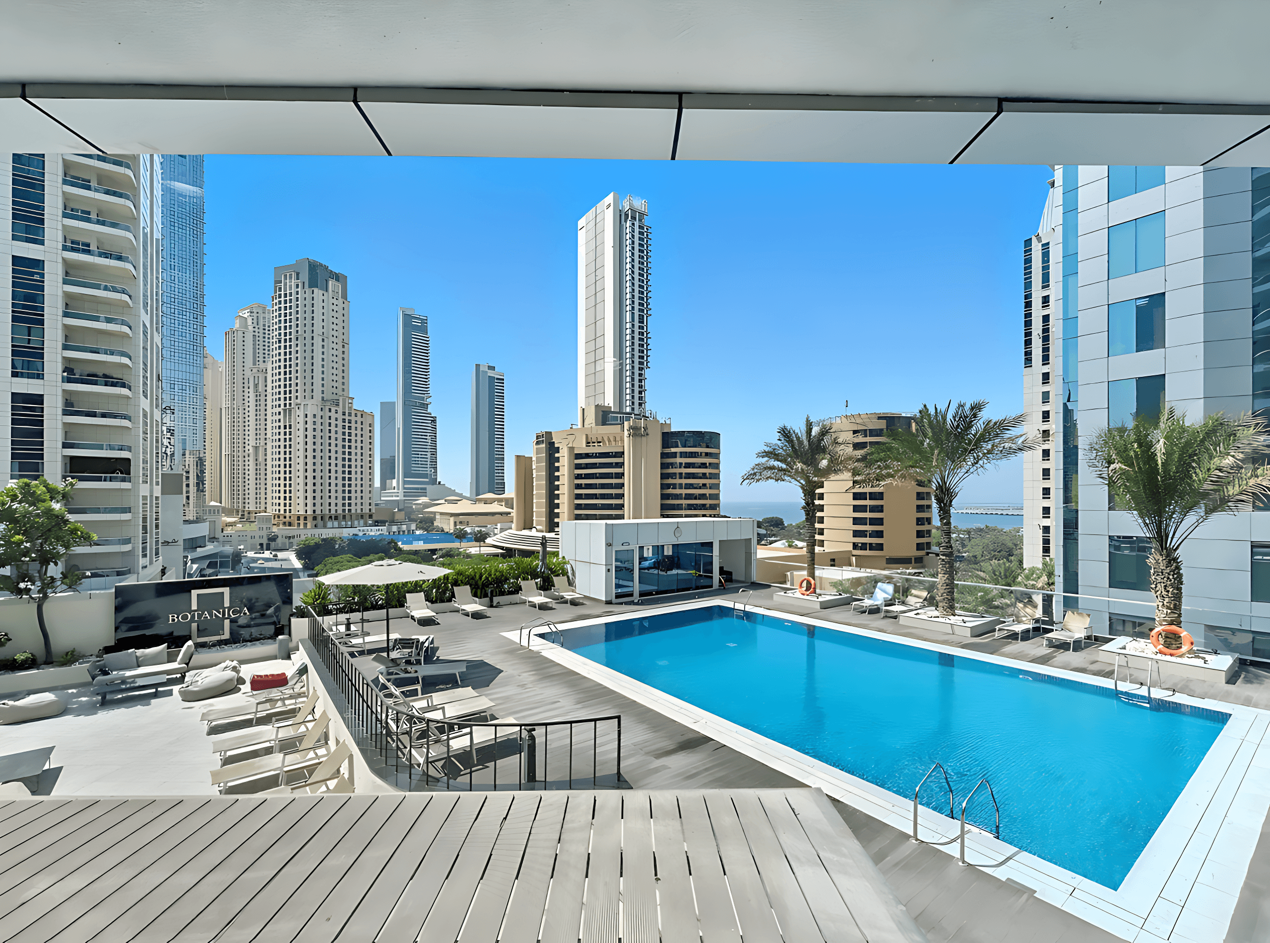 Contemporary living room and kitchen area in Botanica Tower, highlighting modern decor and an open-concept layout.