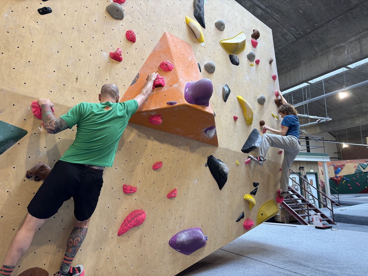 Twee personen aan het boulderen tijdens team event