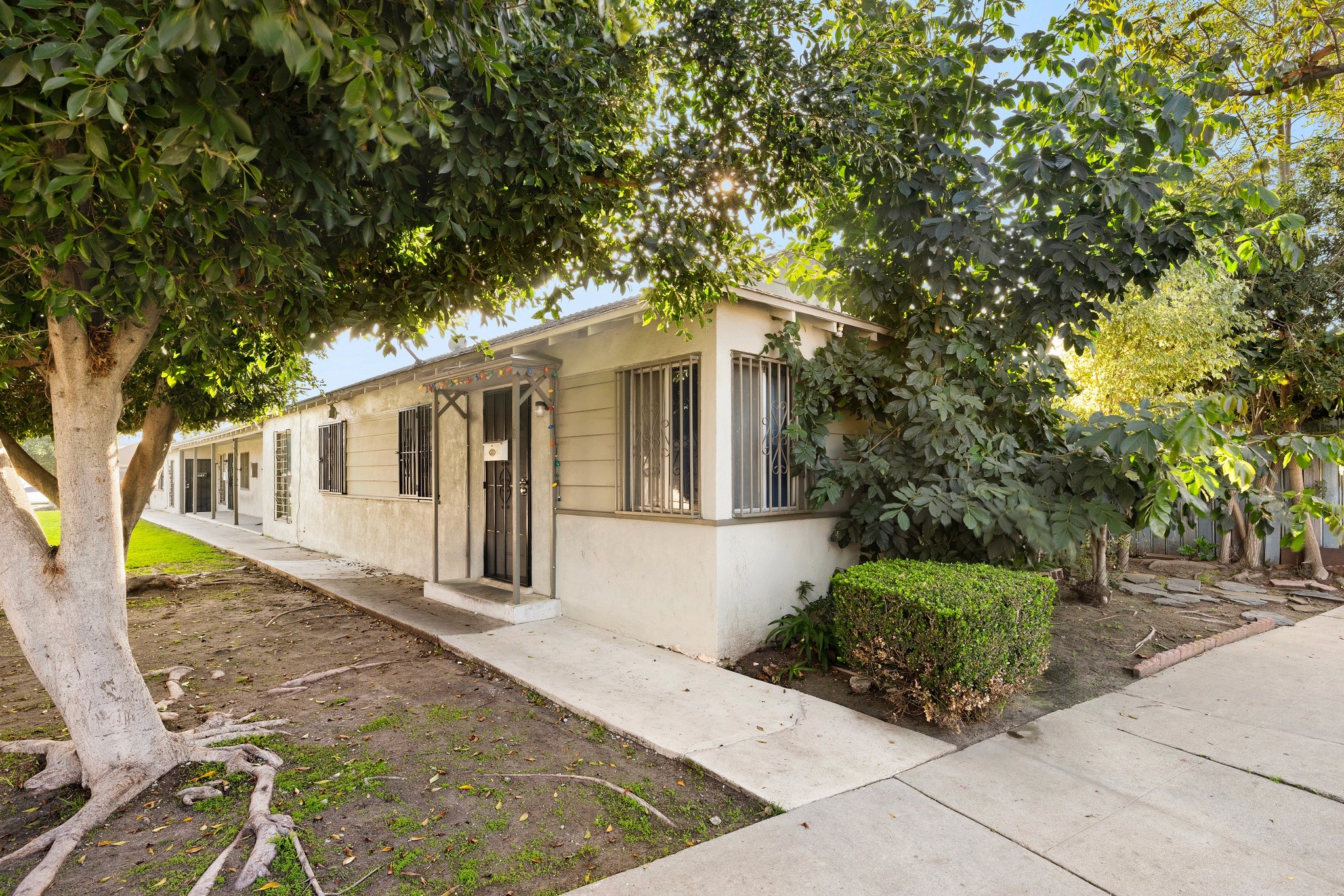 Sidewalk frontage and exterior façade of 1105 E Hyde Park with mature landscaping.