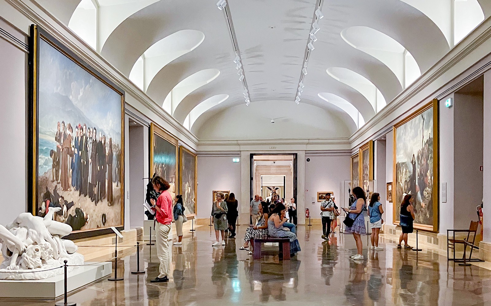 Visitantes observando obras de arte dentro del Museo del Prado, Madrid.