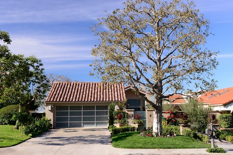 Exterior of Harbor Ridge Transitional Remodel with terracotta roof and mature tree in front yard.