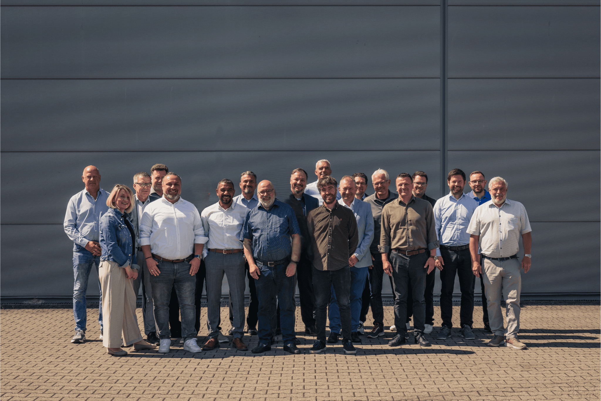 Das Mitarbeiter-Team der Firma Winterhalder steht zusammen im Freien und trägt eine Mischung aus Freizeit- und formeller Kleidung.