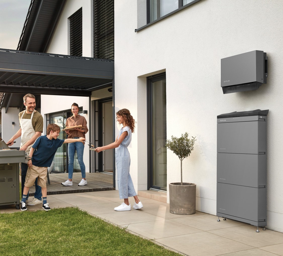 Ein EcoFlow Speichersystem hängt installiert an einer Wand, davor ist eine fröhliche Familie zusehen
