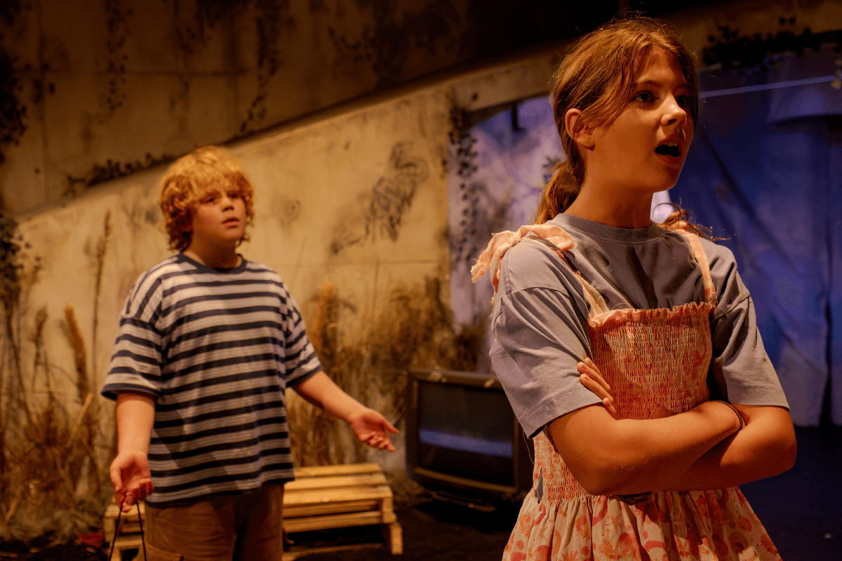 A boy talking to a girl who is facing away from him