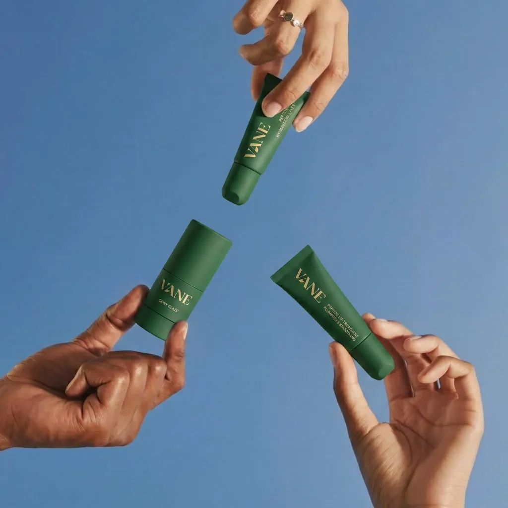 Three hands with green VANE cosmetic tubes. Product branding, design, and art by a branding expert.