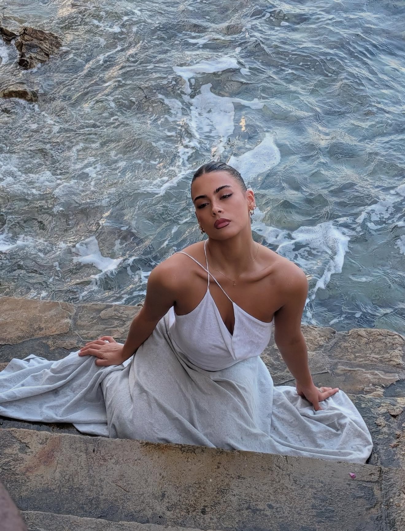 jade gattoni avec un robe blanche devant l'ocean