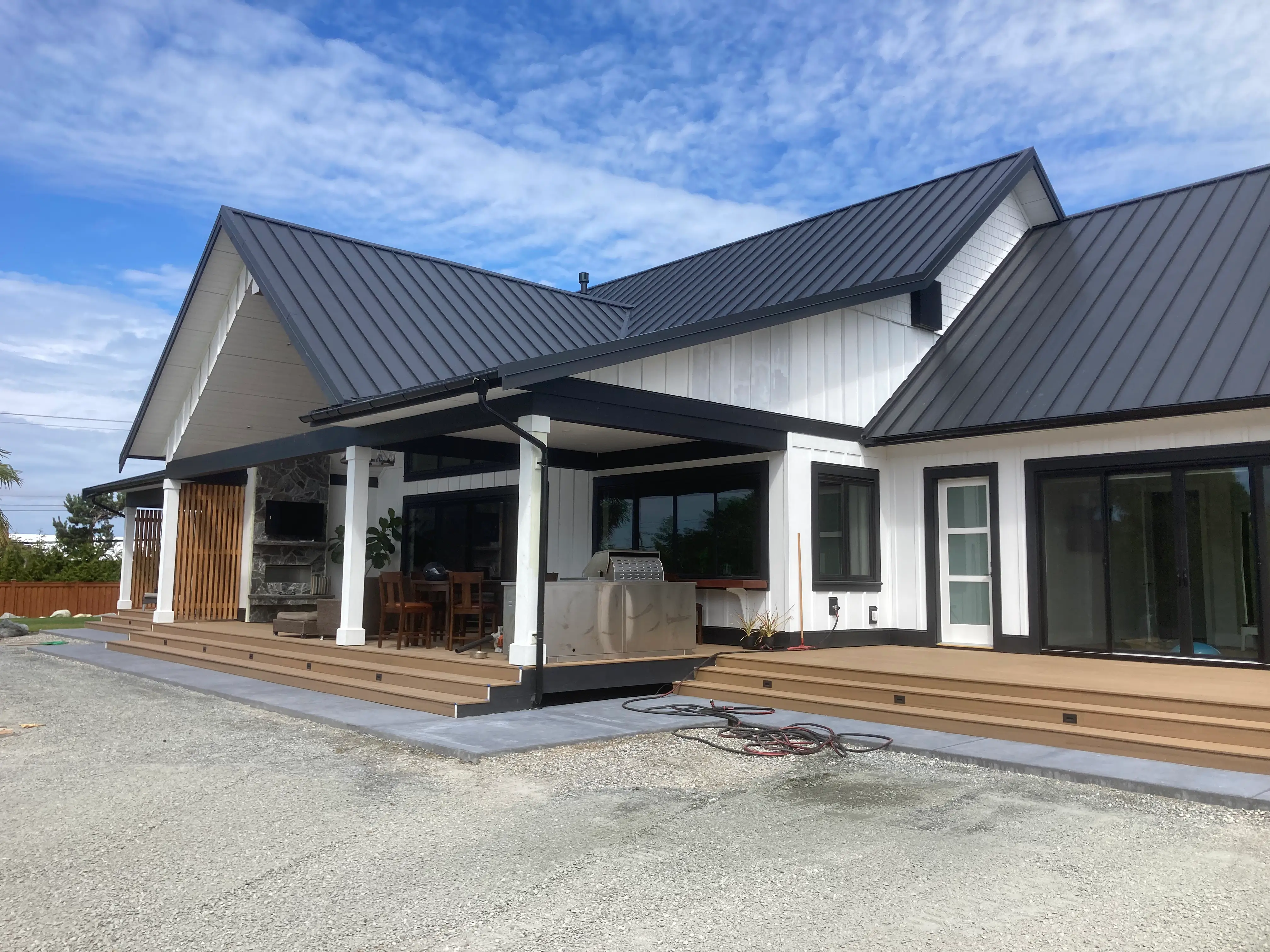 Custom outdoor living space with covered patio, wood deck, and built-in outdoor kitchen.