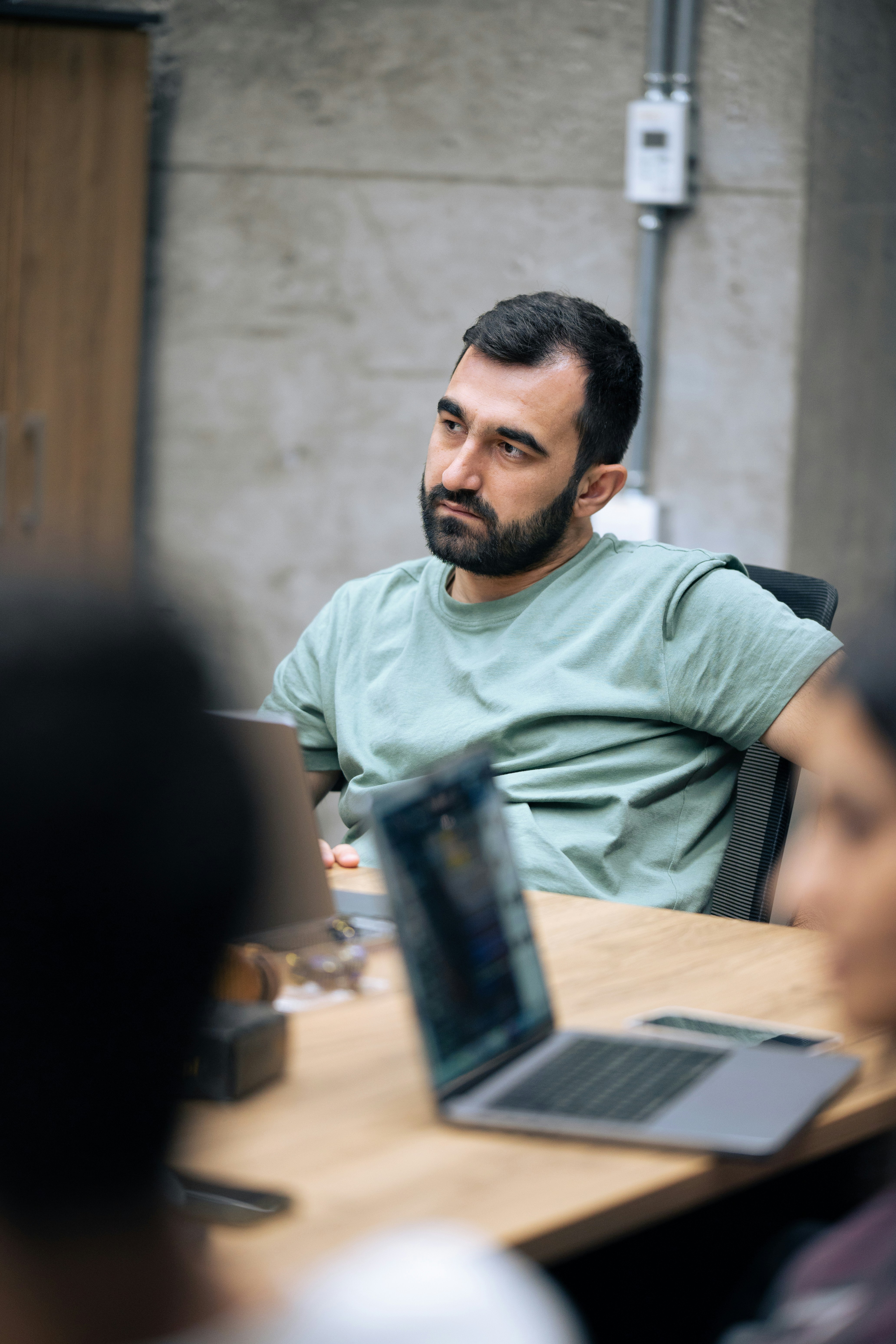 A man sitting at a table with a laptop in front of him