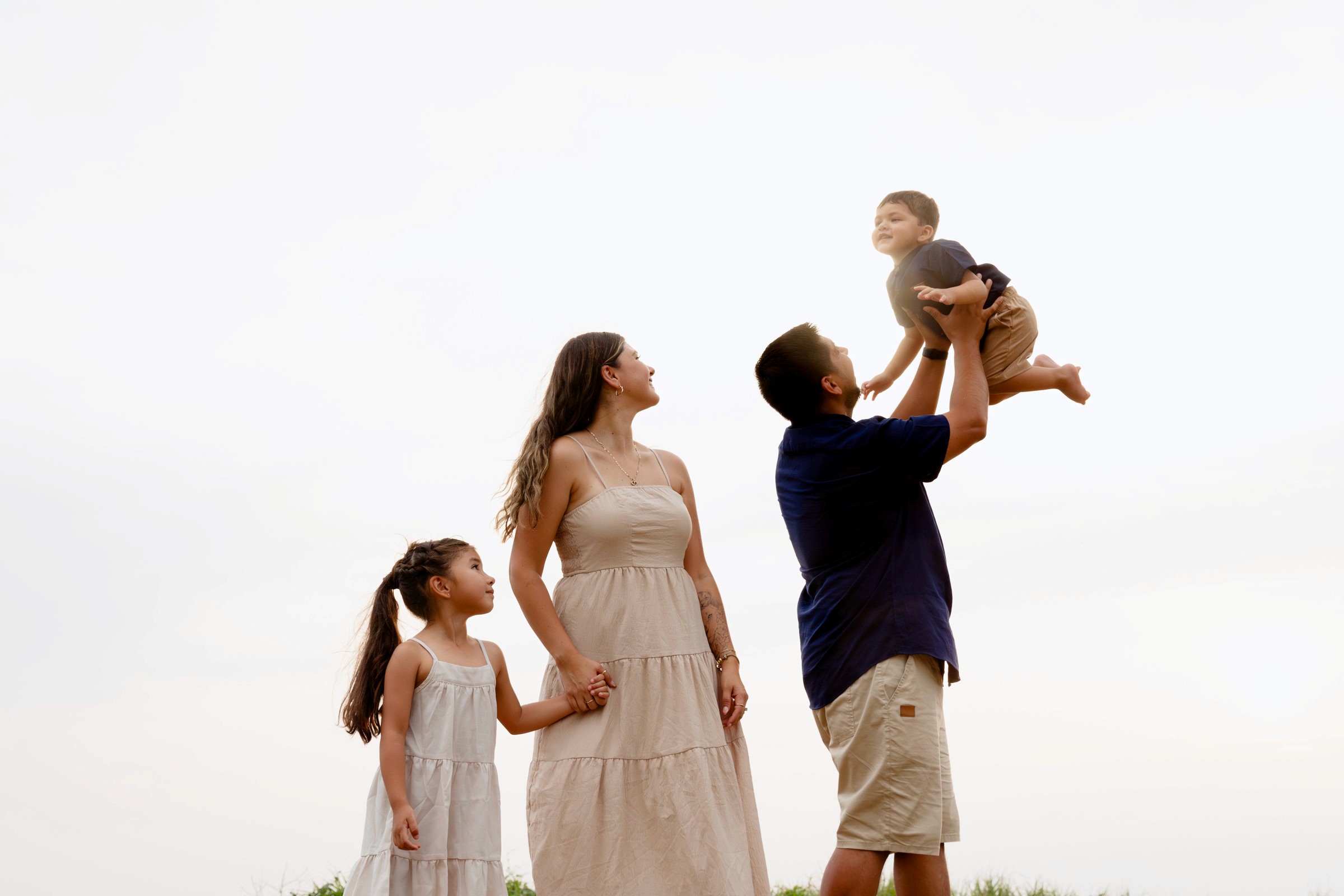 Fotografía de familia disfrutando un momento juntos en la playa