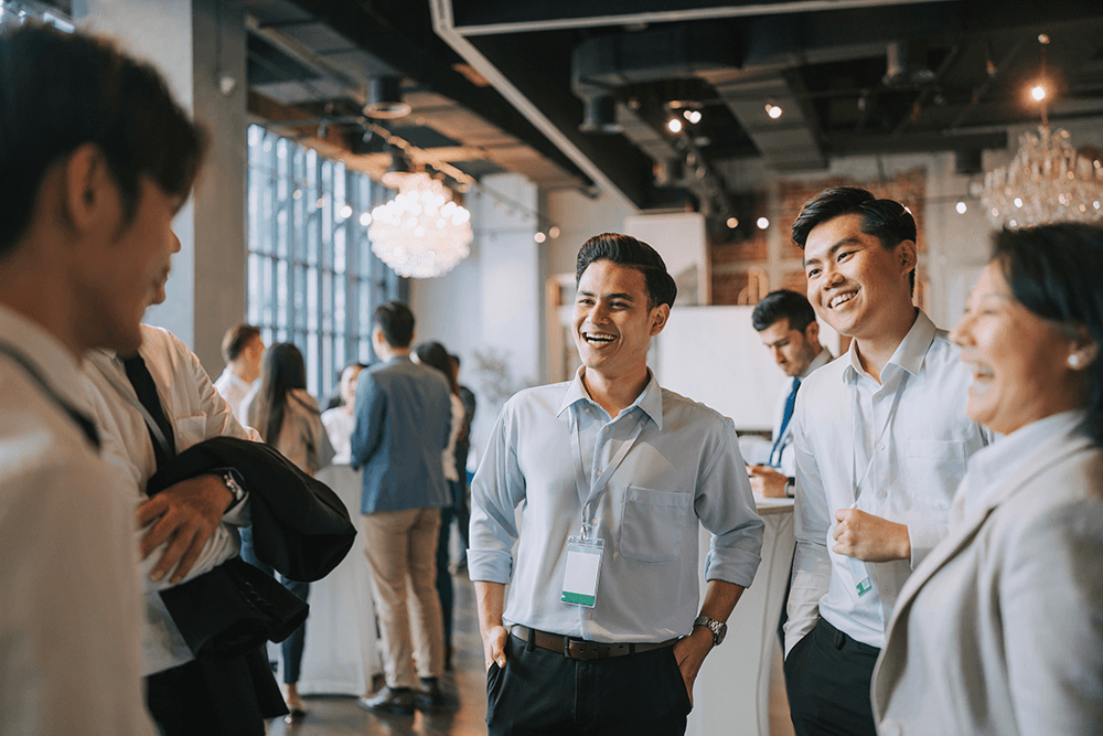Asian business professionals engage in conversation at a networking event, sharing ideas and fostering connections for innovation.