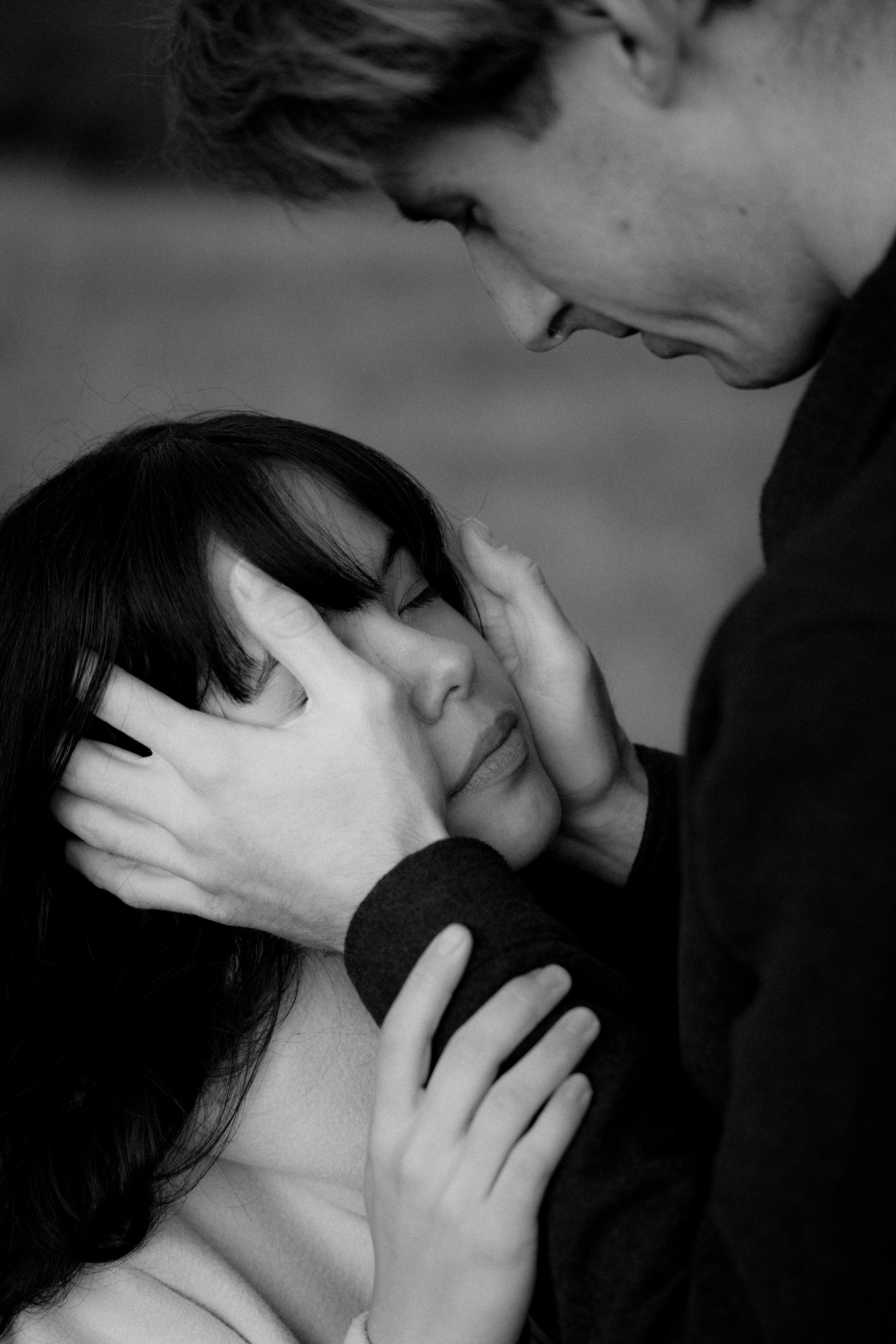 Black and white close-up of a man cradling his partner's face