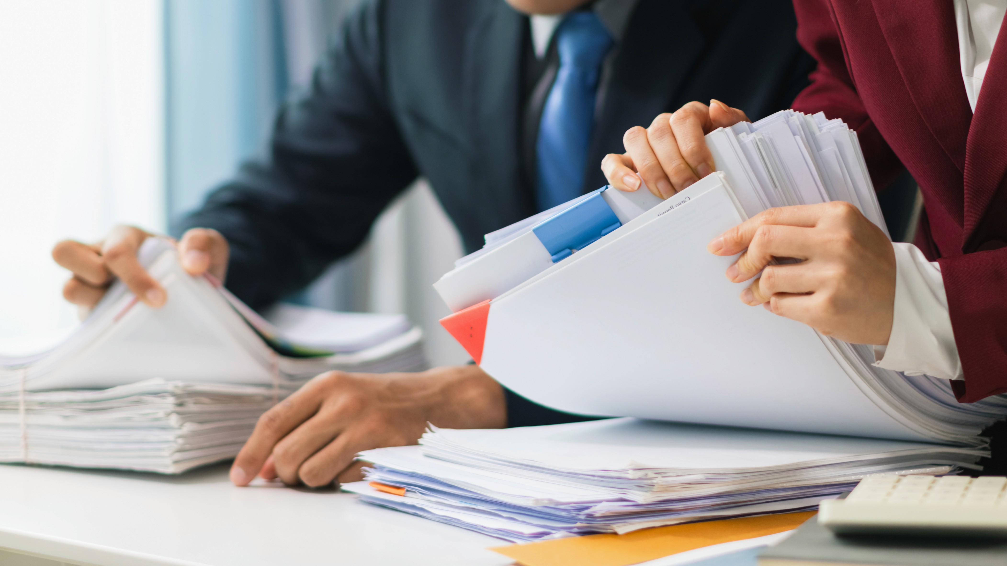 Two professionals reviewing files