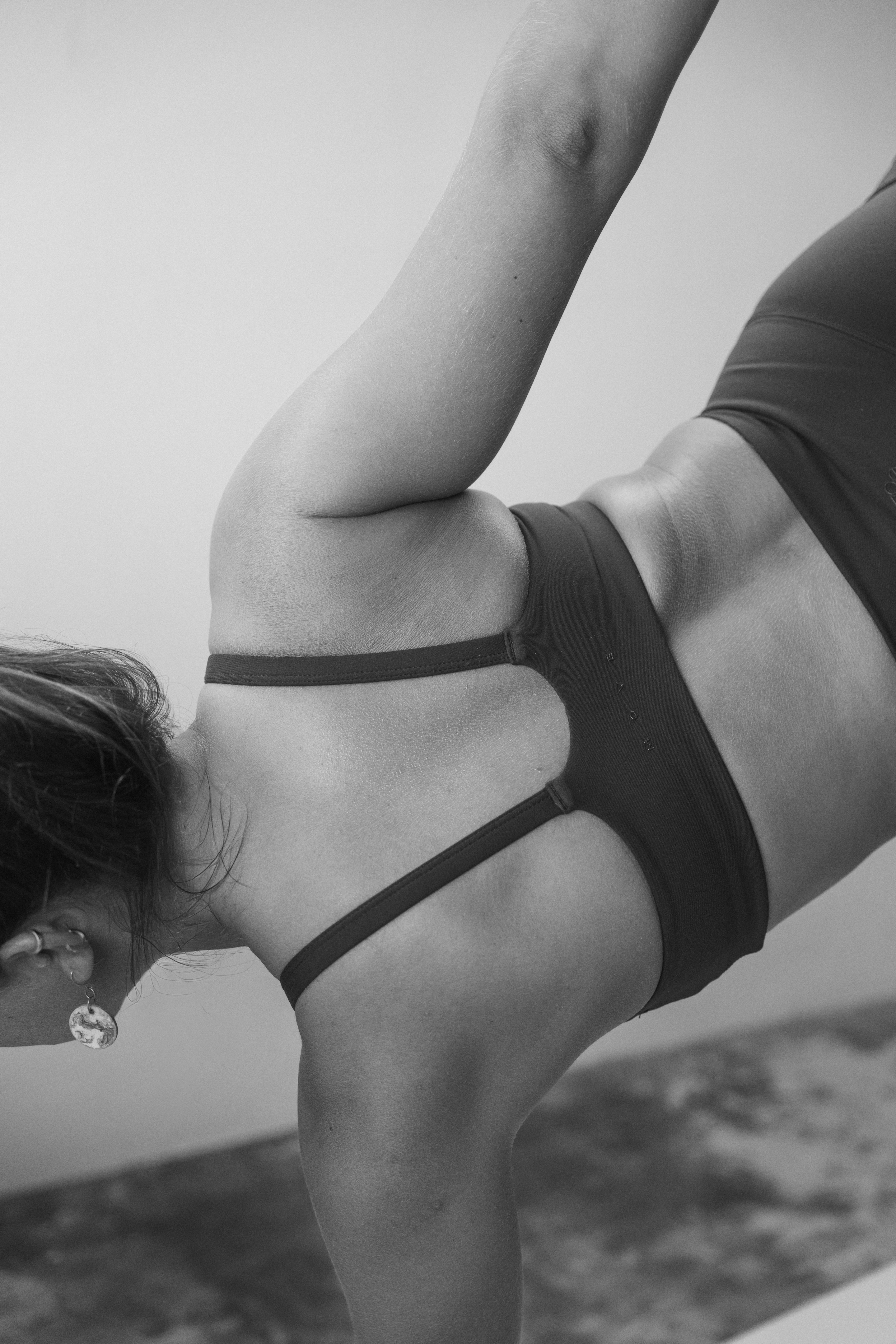 Girl laying on the sand looking to the back 