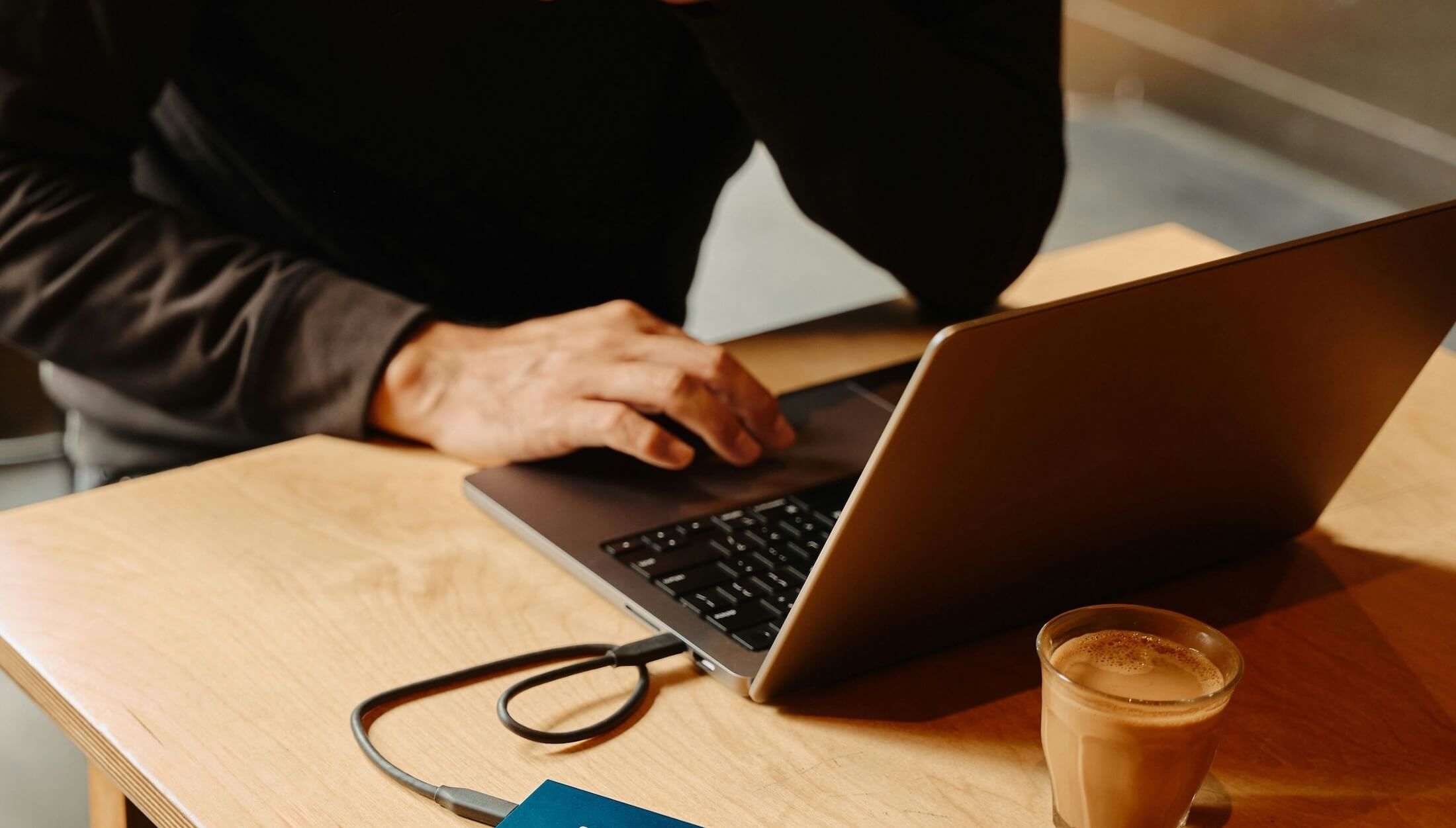 A man working on a laptop on a wooden desk - Boldway blog post on what investors look for on a startup website