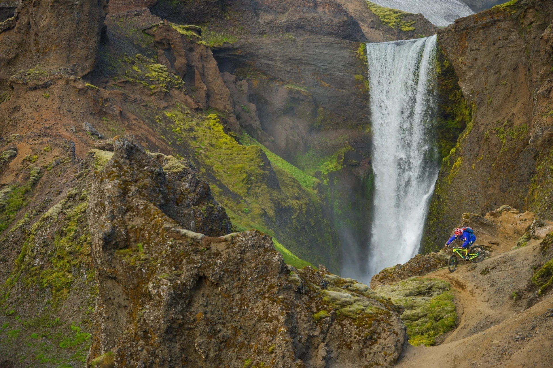 Riding MTB near waterfall on mountains