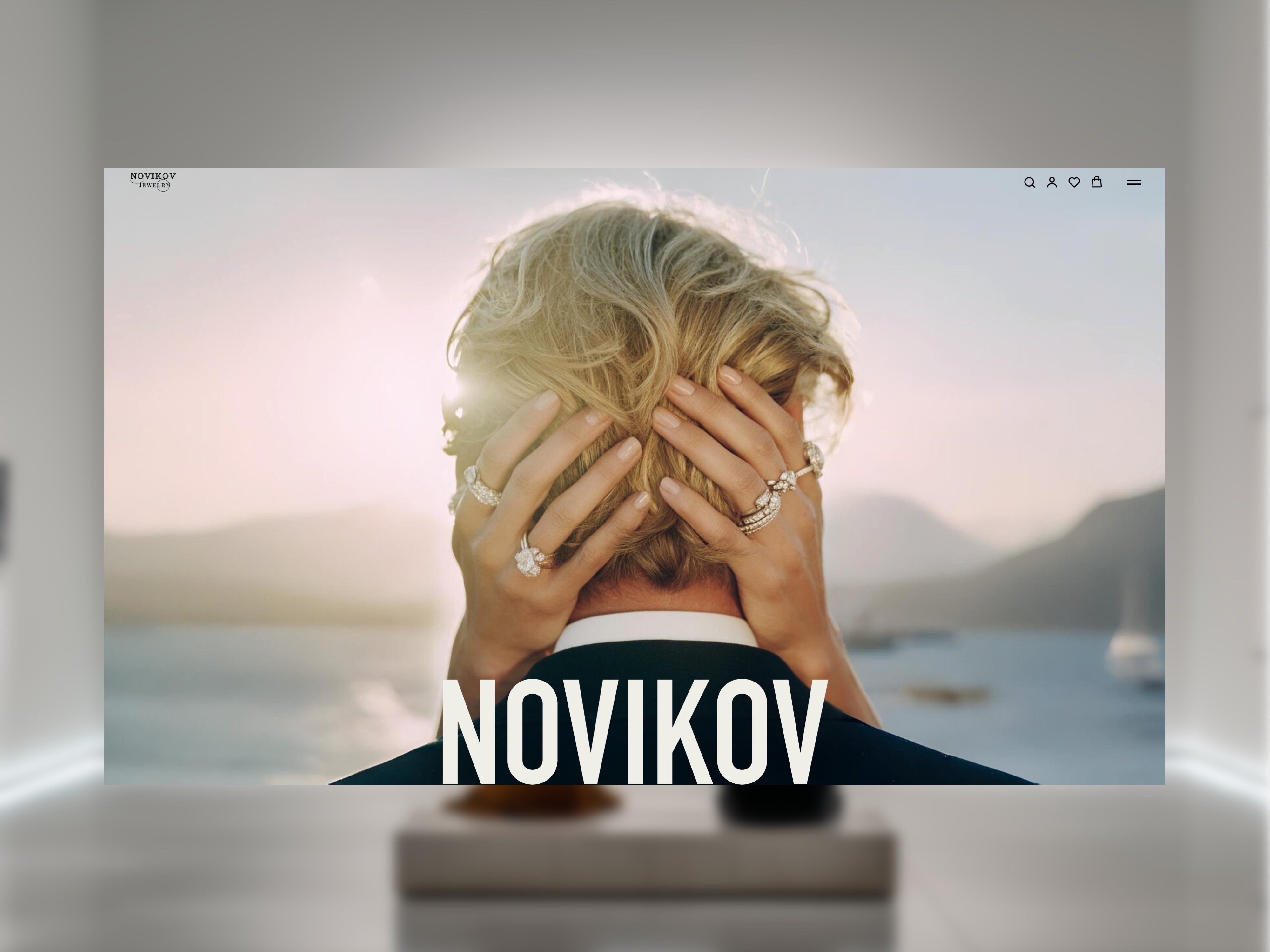 Close-up of a couple embracing with a mountain and sea view behind them, Novikov text below.