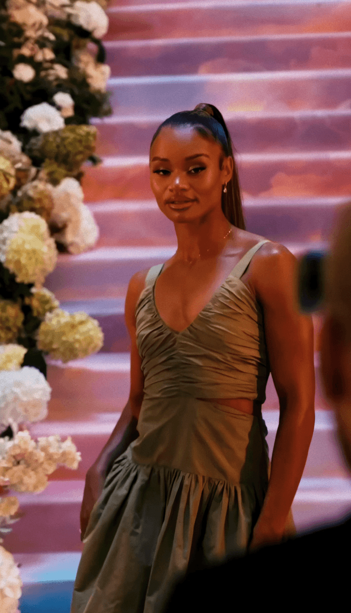 Dancer in black outfit with arms raised, arching backwards