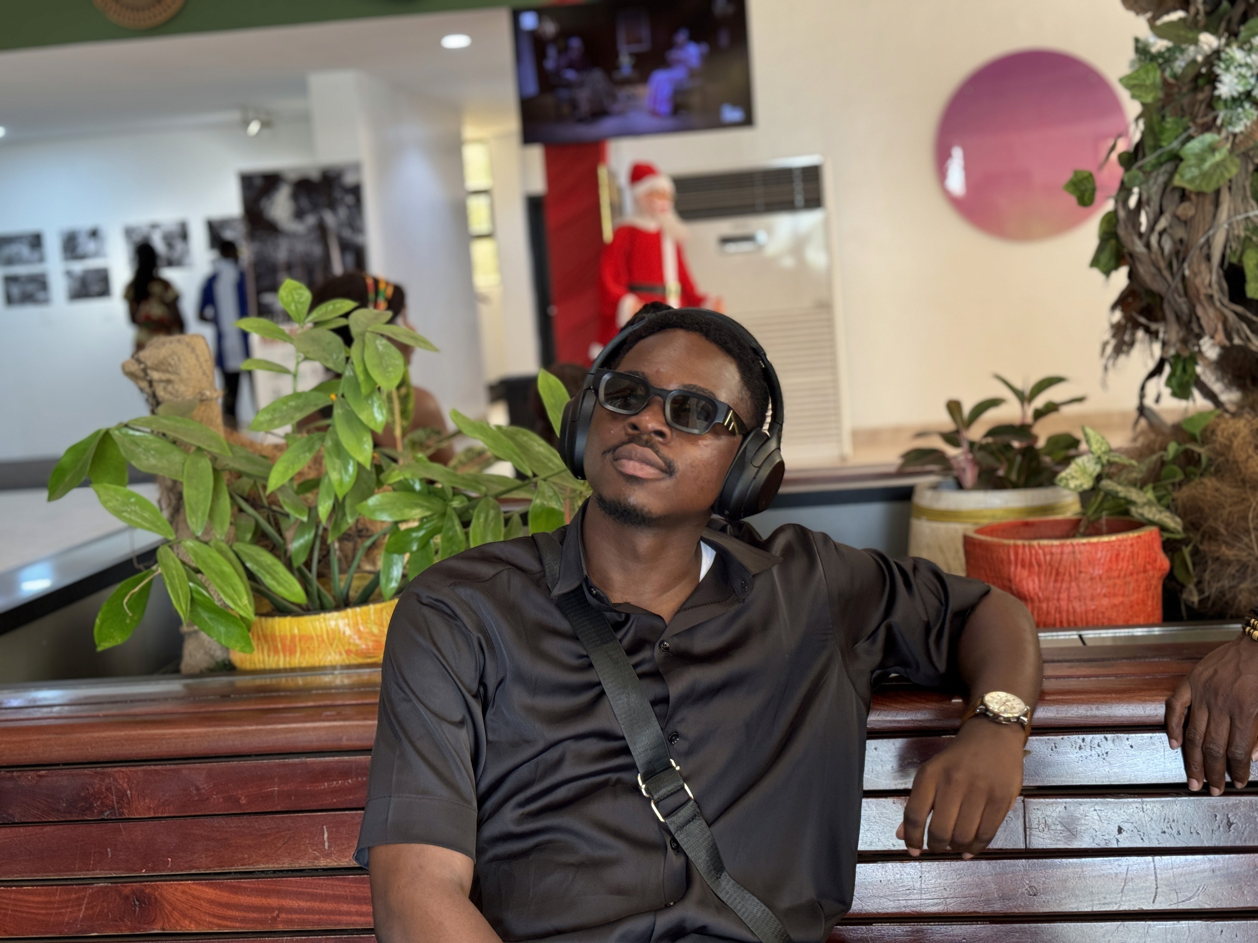 A thoughtful young person with dark hair gazes to the side, captured in soft black and white lighting.