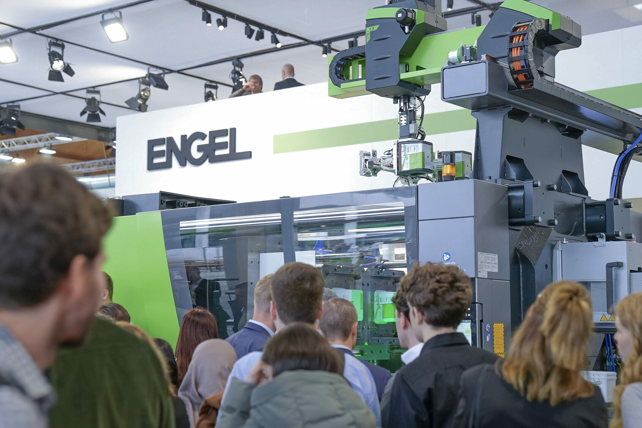 Besucher drängen sich an einem Messestand der Fakuma