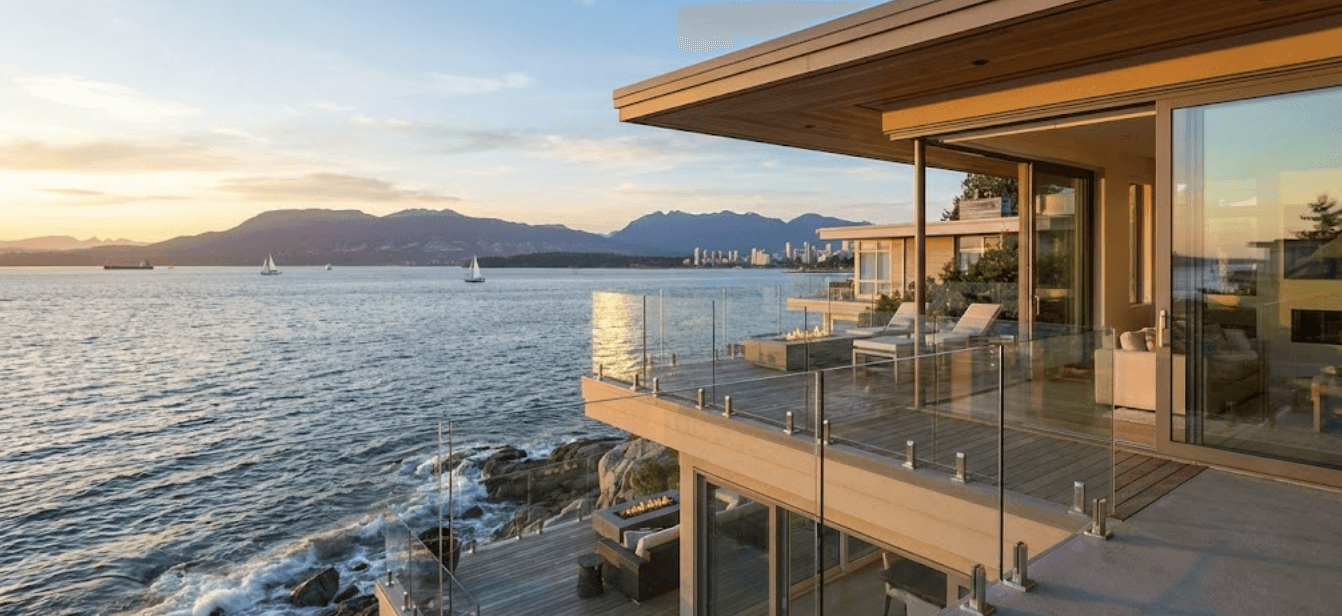 Custom waterfront deck with frameless glass railings at sunset overlooking Vancouver harbor