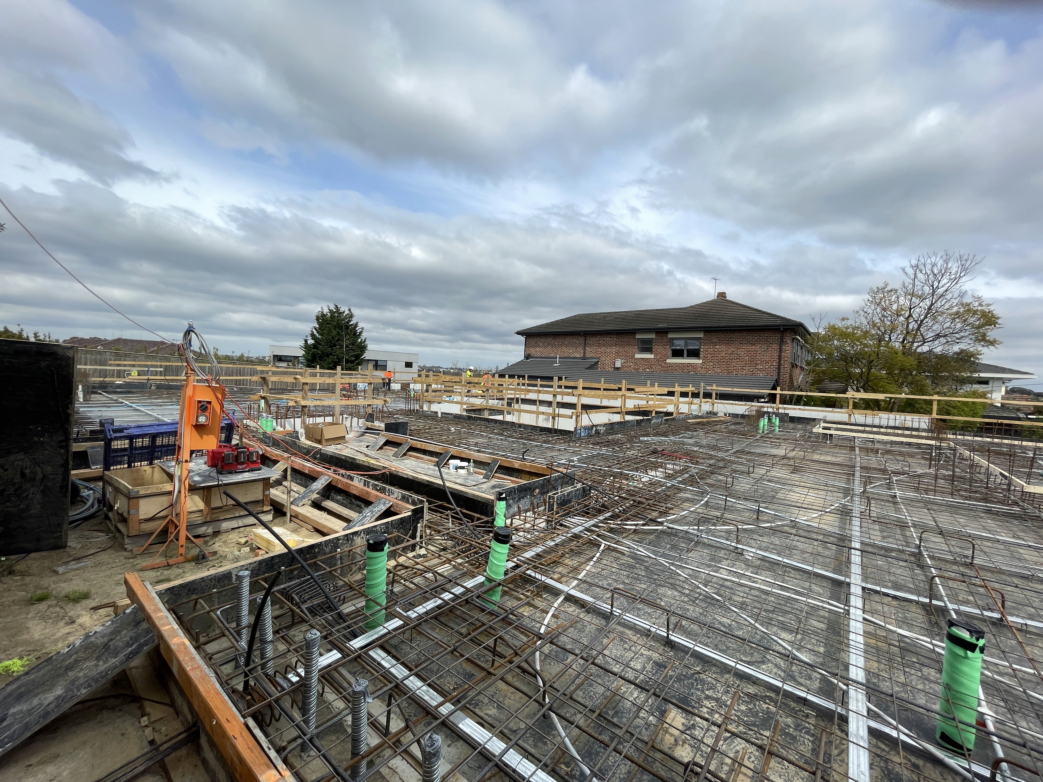 Site site visit photo showing blue sky and steel reinforcing to concrete floor slab taken by SubsQS