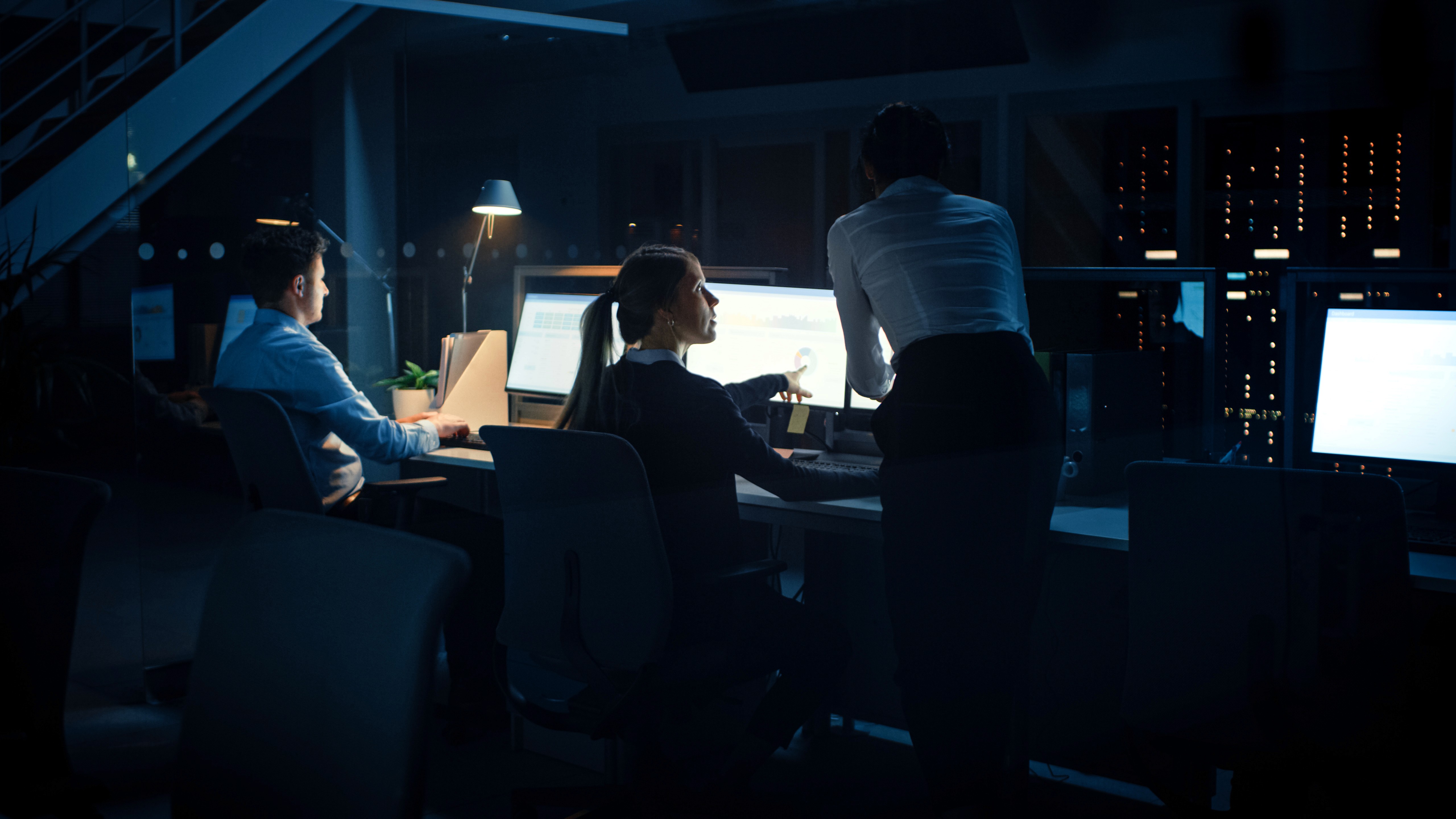 Collaborative work session overhead view of six people collaborating at a rustic wooden table with coffee, papers, and a laptop