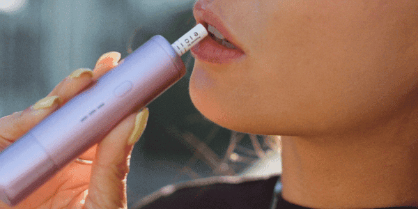 A relaxed individual inhaling from the Odin Device with a Nano Joint™, highlighting the smooth and clean cannabis experience.