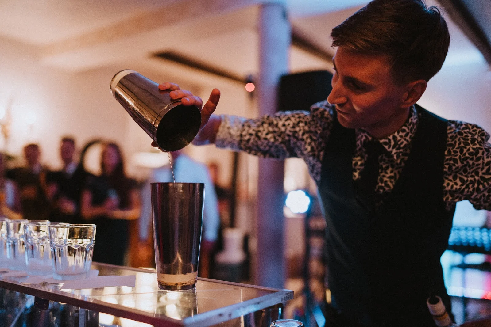 Drink bar na weselu z barmanem zachwycającym gości podczas pokazu.