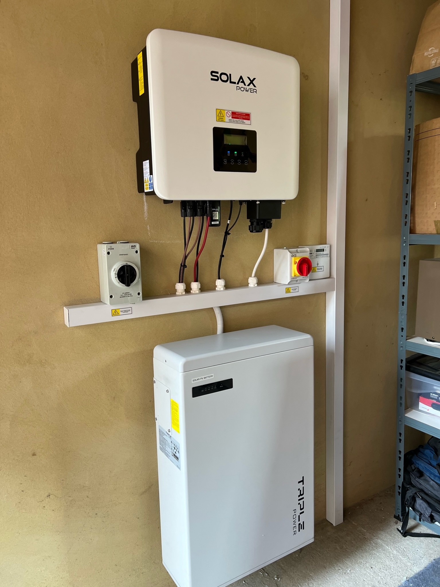 SolaX inverter, isolators and battery installed in the garage at Nina's home