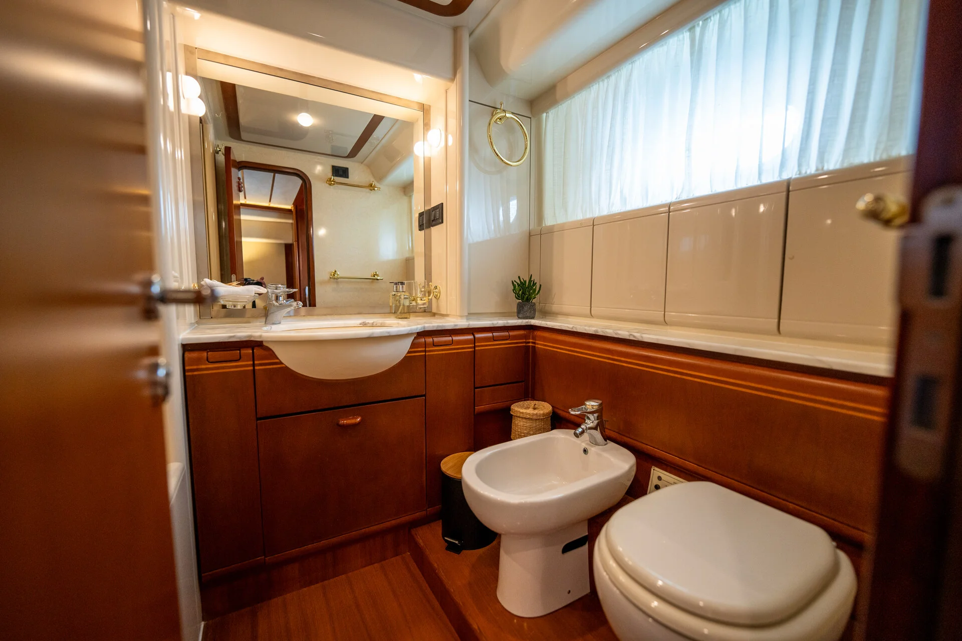 White Rock 36 speedboat with captain at helm cruising calm blue waters near Paros coastline with hills in background.