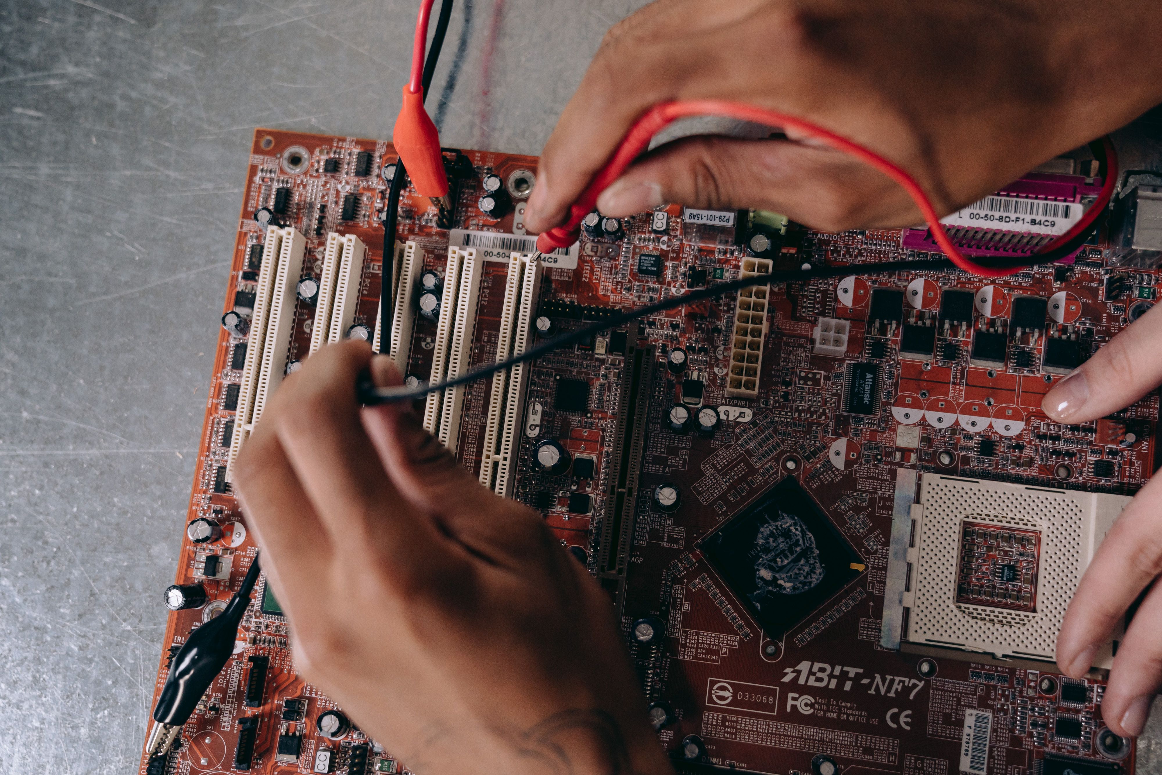 close-up-of-hands-working-on-a-motherboard,-showcasing-electronic-components-and - mikhail-nilov (pexels)