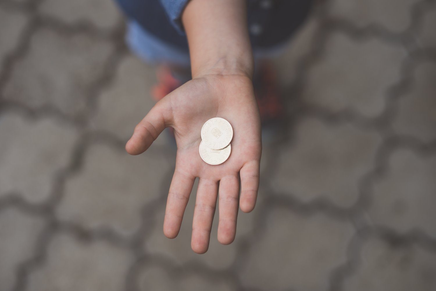 Hand holding two gold coins