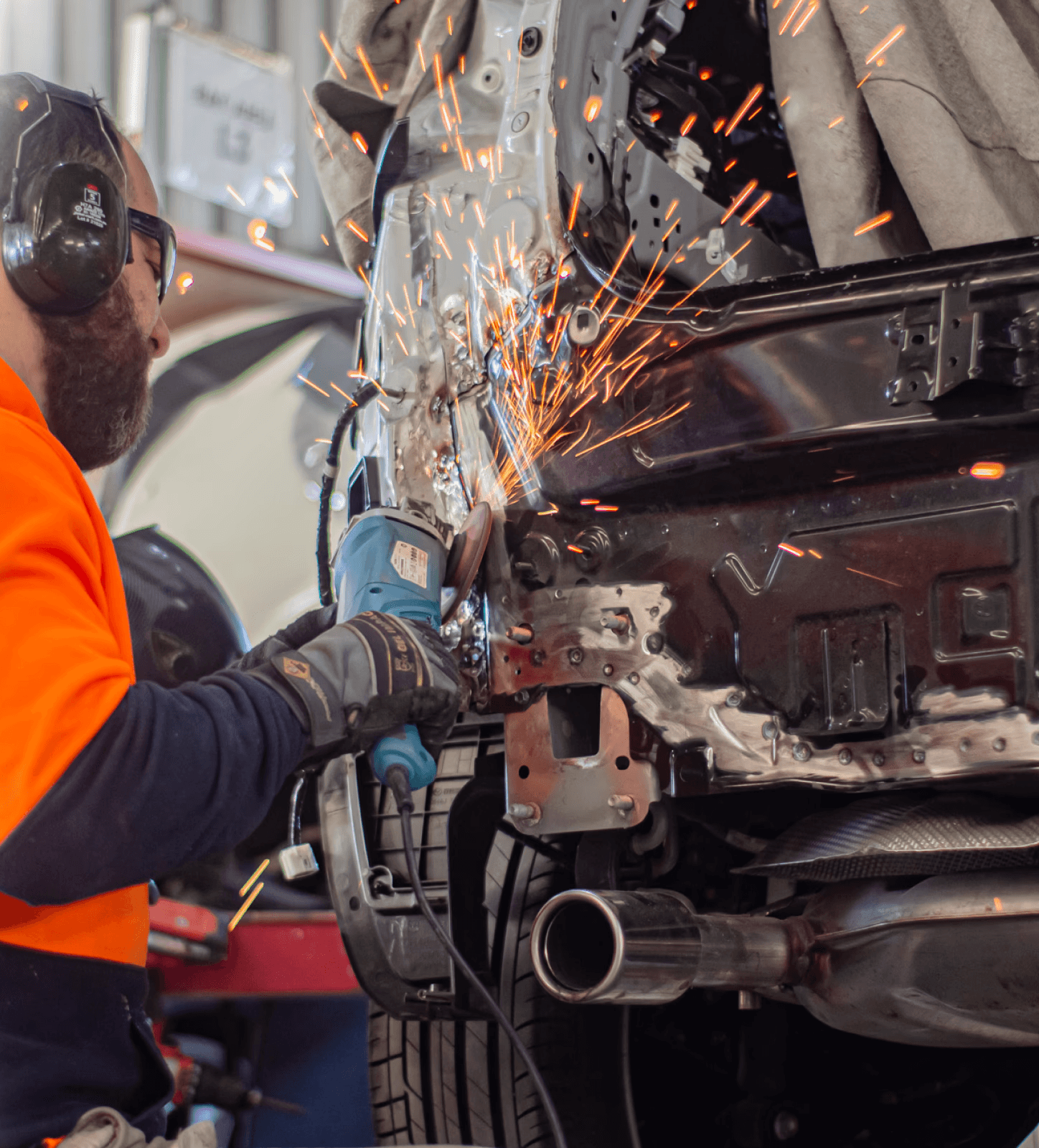 Mechanic grinding car body, sparks flying