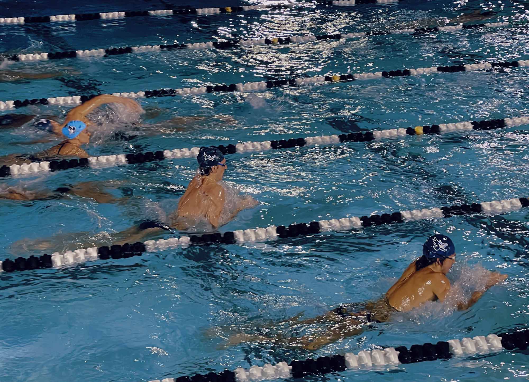  Collaborative work session overhead view of six people collaborating at a rustic wooden table with coffee, papers, and a laptop