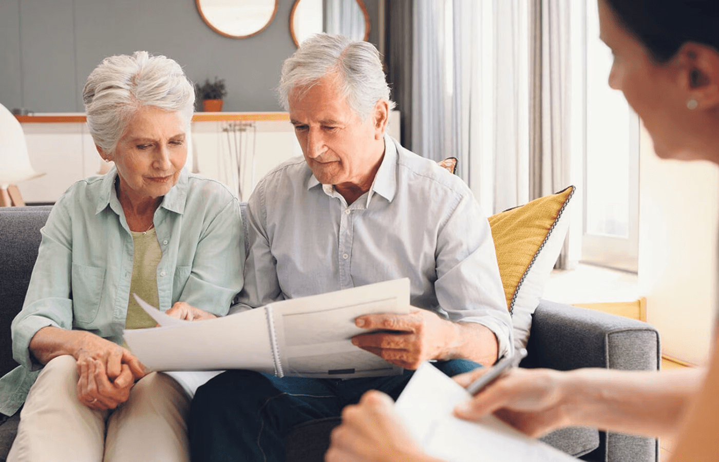 Two elderly people looking at a binder