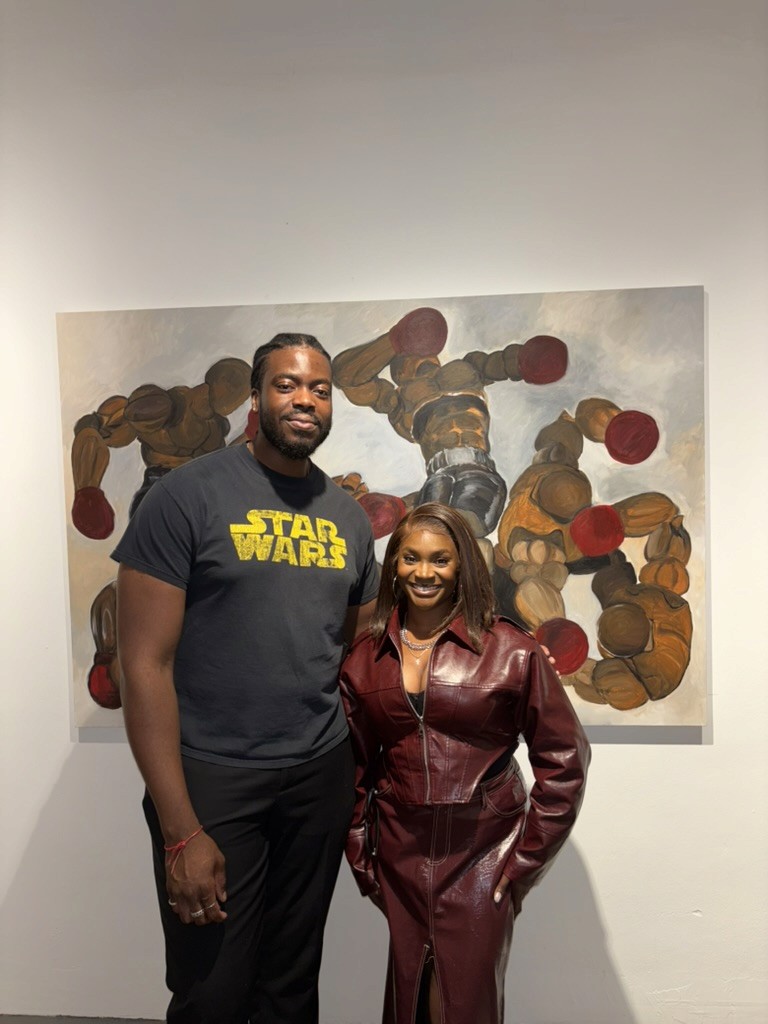 Two exhibition guests standing in front of a painting